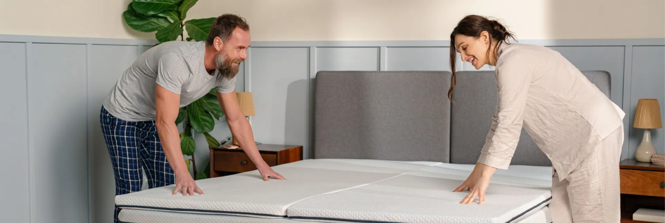 A married couple making the bed on their Emma Mattress