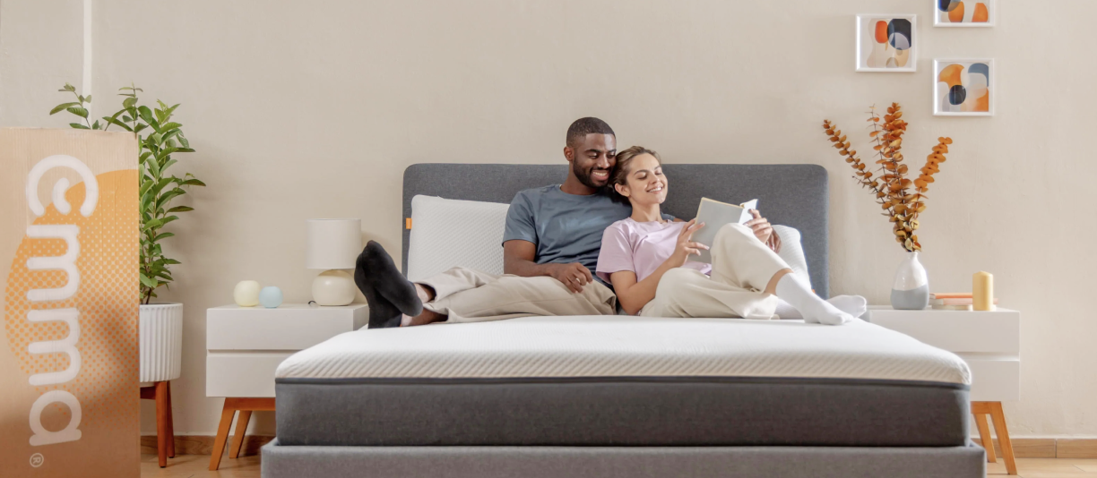 A couple laying on an Emma Mattress reading together